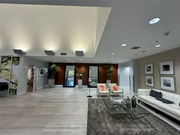 a living room with couches and kitchen view with wooden floor