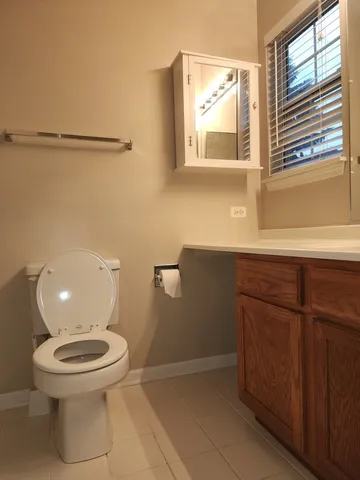 a bathroom with a toilet a sink and a window