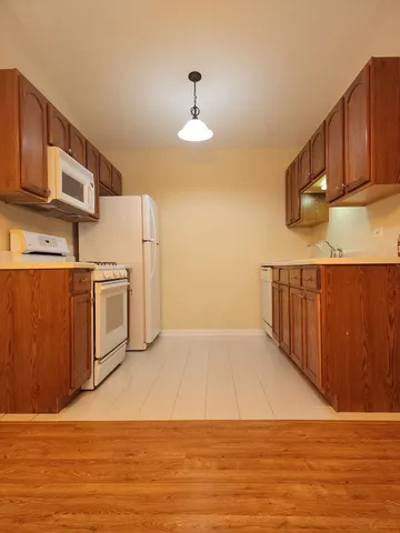 a kitchen with stainless steel appliances granite countertop a refrigerator a stove and a wooden floors