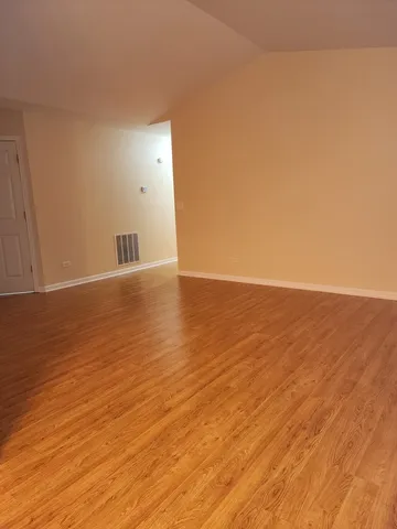 a view of an empty room and wooden floor