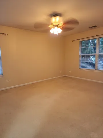 en empty room with windows and chandelier