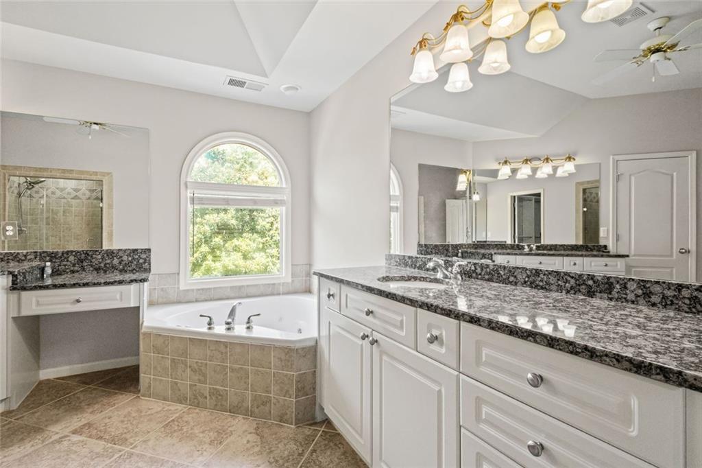 12857 Waterside Drive Alpharetta, GA 30004 - Photo 26 of 60 a bathroom with a granite countertop bathtub sink and mirror