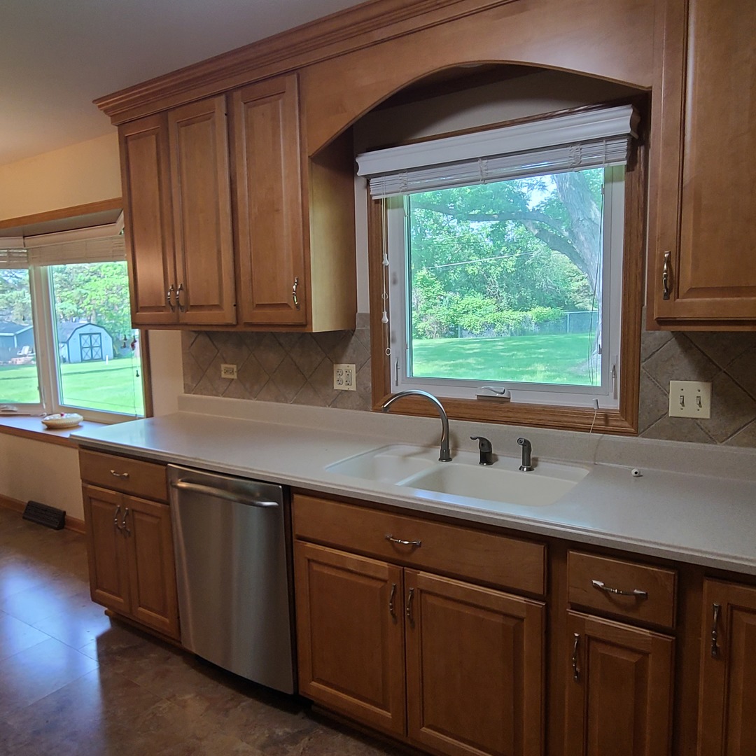 12N238 Hilltop Road Elgin, IL 60124 - Photo 3 of 21 a kitchen with granite countertop wooden cabinets a sink and a window