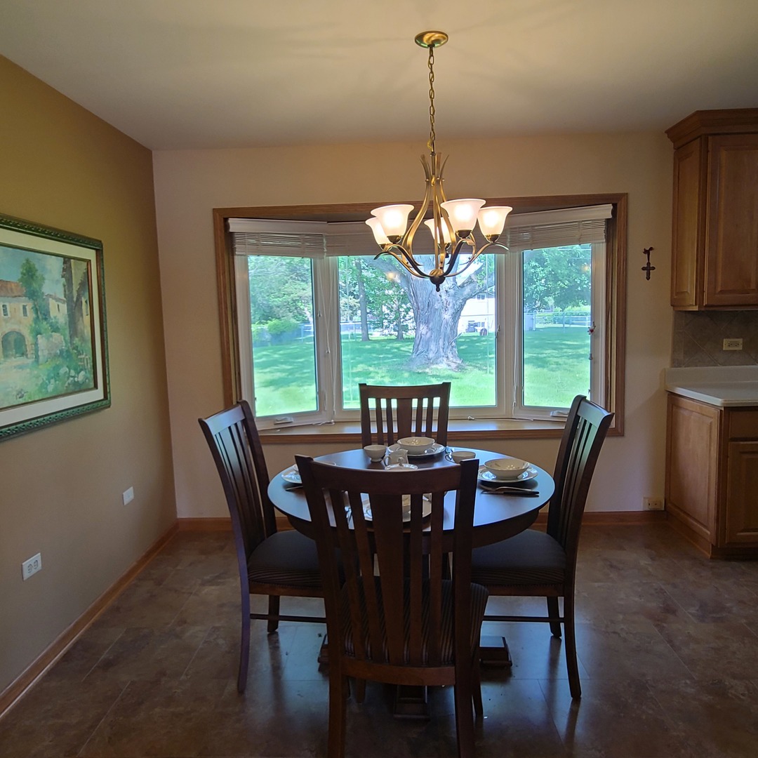12N238 Hilltop Road Elgin, IL 60124 - Photo 4 of 21 a view of a dining room with furniture a chandelier and wooden floor