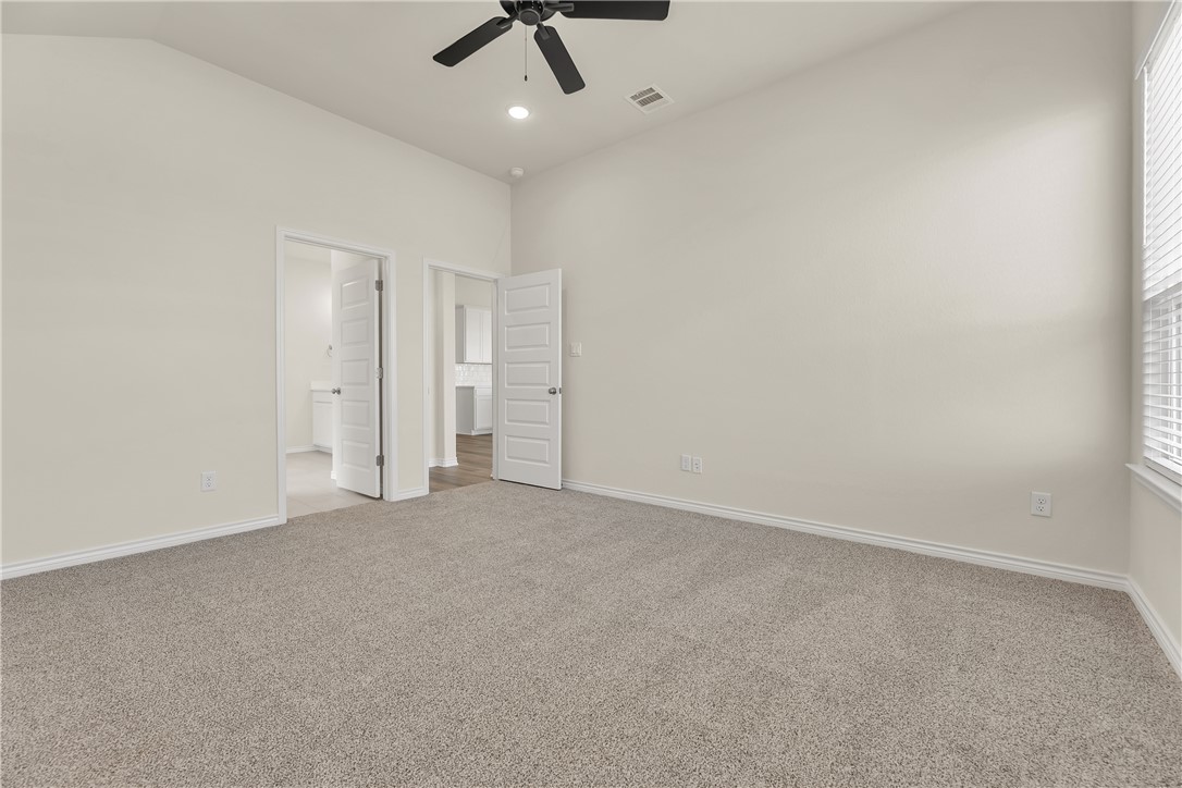 7804 Redbud Road Navasota, TX 77868 - Photo 12 of 26 an empty room with a ceiling fan and carpet
