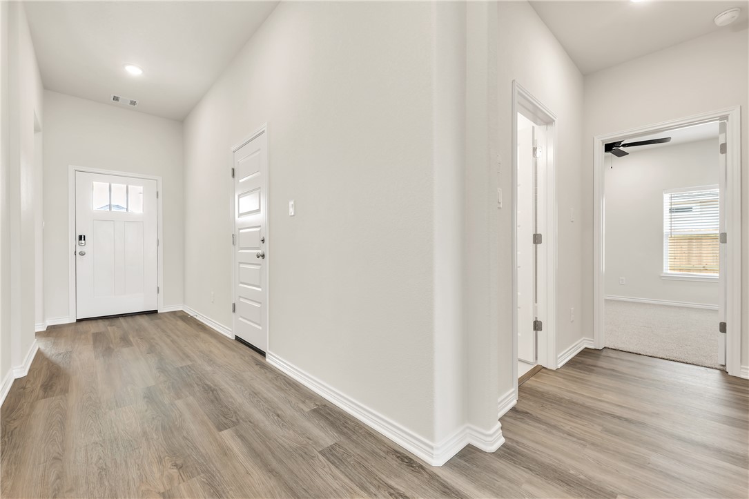 7804 Redbud Road Navasota, TX 77868 - Photo 19 of 26 an empty room with wooden floor & windows and bathroom