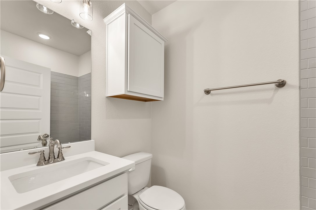 7804 Redbud Road Navasota, TX 77868 - Photo 21 of 26 a bathroom with a toilet sink and mirror