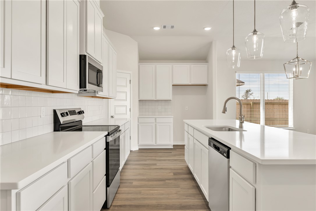 7804 Redbud Road Navasota, TX 77868 - Photo 8 of 26 a kitchen with stainless steel appliances granite countertop a sink stove and refrigerator