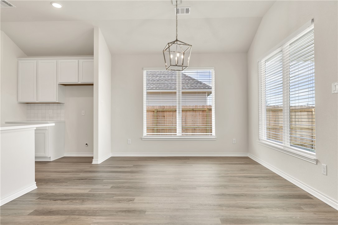 7804 Redbud Road Navasota, TX 77868 - Photo 10 of 26 a view of an empty room with wooden floor and a window