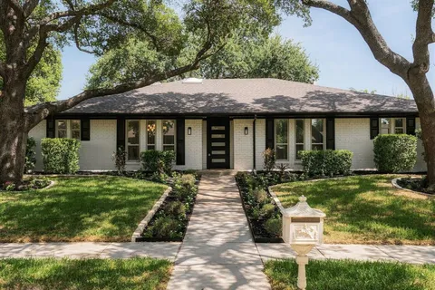 a front view of a house with yard and green space