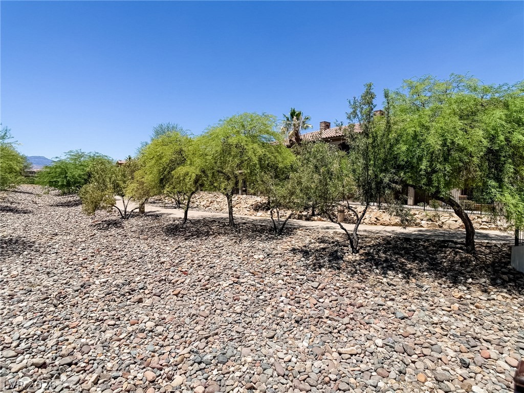 7701 West Robindale Road, Unit 110 Las Vegas, NV 89113 - Photo 21 of 21 Mature trees and natural rock landscaping define this desert-inspired property.