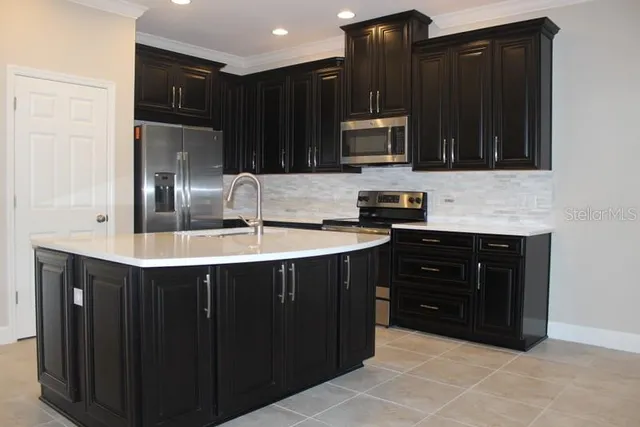 a kitchen with stainless steel appliances granite countertop a refrigerator and a stove top oven