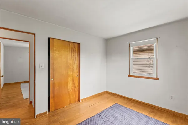 a view of an empty room window and wooden floor