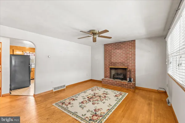 a view of an empty room with a fireplace and a window