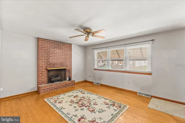 a view of an empty room with a fireplace and a rug