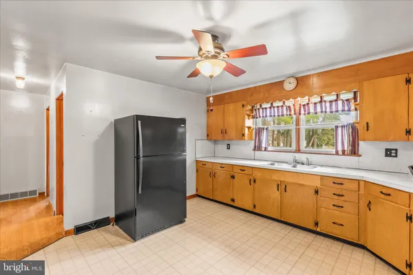a kitchen with granite countertop a refrigerator and cabinets