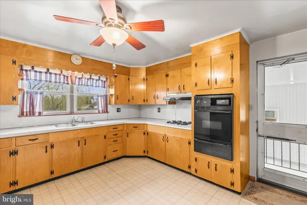 a kitchen with stainless steel appliances granite countertop a sink and cabinets with wooden floor