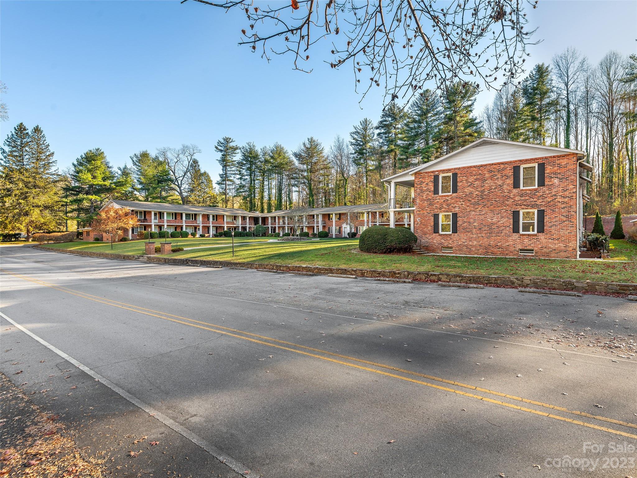 102 Boyd Drive, Unit 5B Flat Rock, NC 28731 - Photo 15 of 16 a front view of a house with a garden and trees