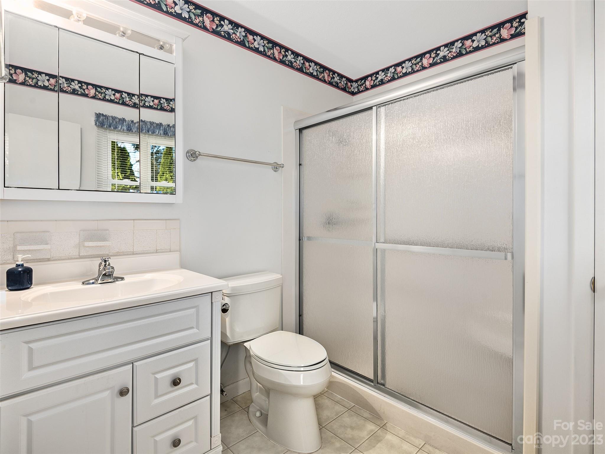 102 Boyd Drive, Unit 5B Flat Rock, NC 28731 - Photo 9 of 16 a bathroom with a granite countertop sink mirror vanity and toilet