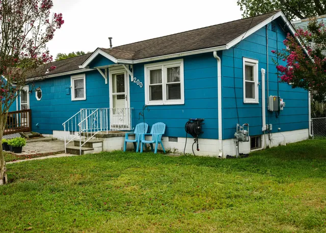 a view of house with a yard and sitting area