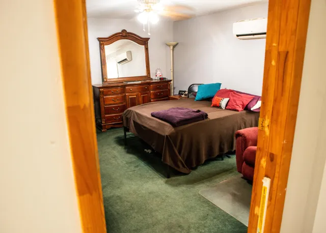 a bedroom with a bed window and dresser