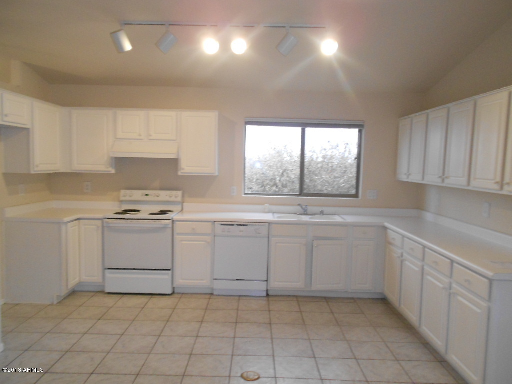 3918 East Agave Road Phoenix, AZ 85044 - Photo 5 of 14 a kitchen with white cabinets appliances and a window
