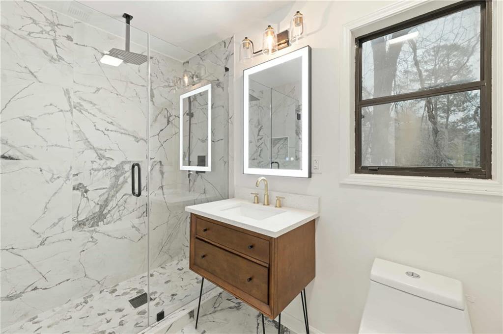 1487 Springwood Drive Southeast, Unit A Smyrna, GA 30080 - Photo 13 of 19 a bathroom with a sink a mirror and a shower