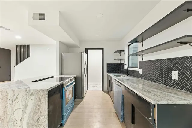 a kitchen with stainless steel appliances granite countertop a sink and a stove