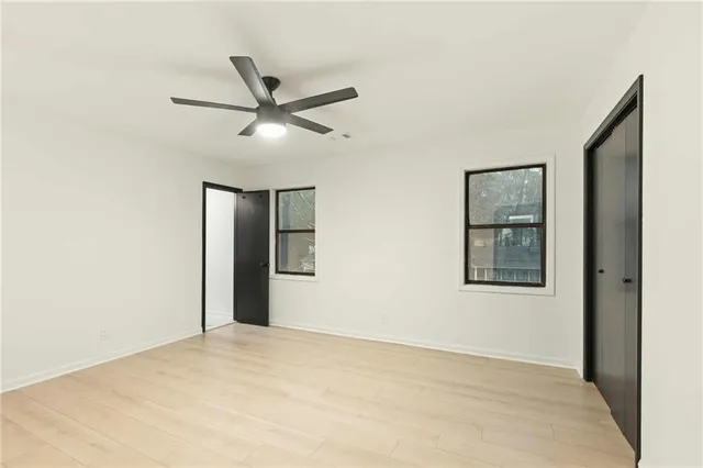a view of a big room with wooden floor and windows in a room