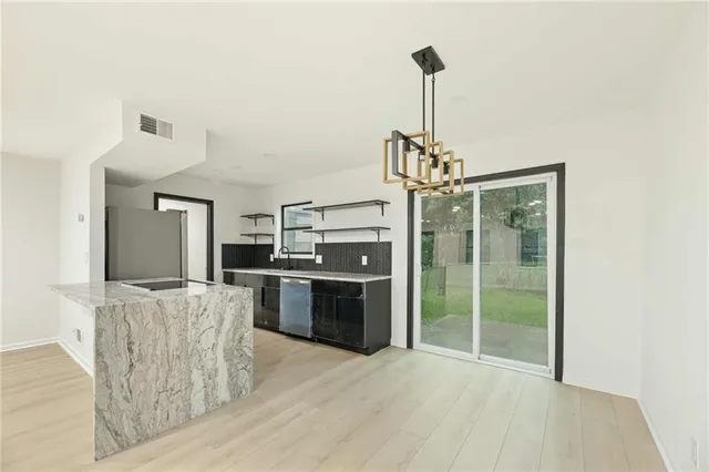 a kitchen with stainless steel appliances granite countertop a refrigerator and a sink