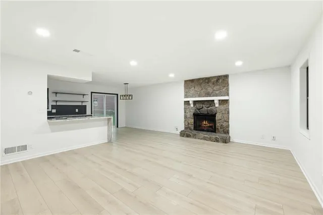 a view of an empty room with a fireplace and a window