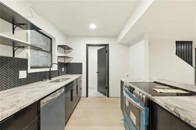 a kitchen with granite countertop a sink and a stove