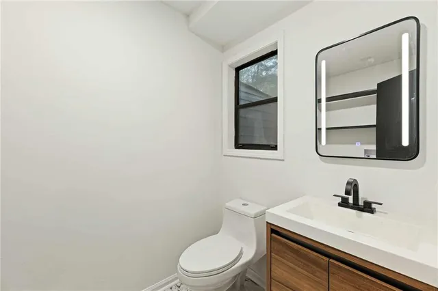 a white toilet sitting next to a bathroom sink