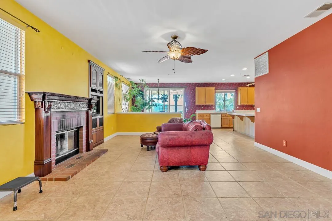 10496 Chaparral Drive Santee, CA 92071 - Photo 12 of 73 a living room with furniture a fireplace and a flat screen tv