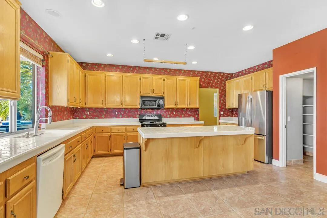 10496 Chaparral Drive Santee, CA 92071 - Photo 17 of 73 a large kitchen with stainless steel appliances a large window and a counter top space