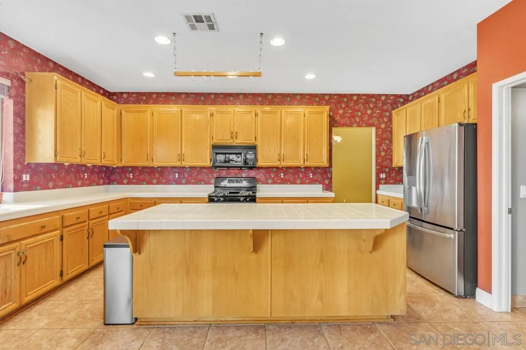 10496 Chaparral Drive Santee, CA 92071 - Photo 18 of 73 a kitchen with stainless steel appliances granite countertop a refrigerator a sink and a stove