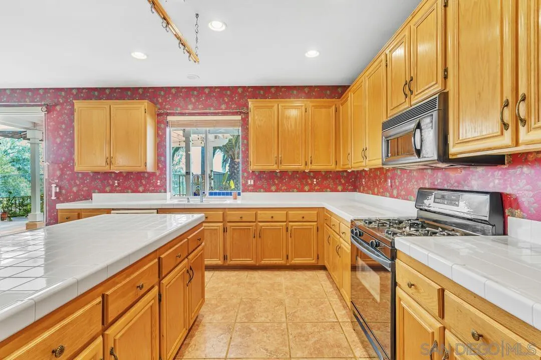 10496 Chaparral Drive Santee, CA 92071 - Photo 21 of 73 a kitchen with stainless steel appliances granite countertop a sink and a stove