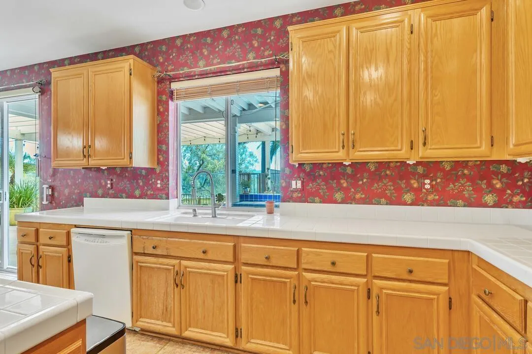 10496 Chaparral Drive Santee, CA 92071 - Photo 22 of 73 a kitchen with stainless steel appliances granite countertop white cabinets a sink and a large window