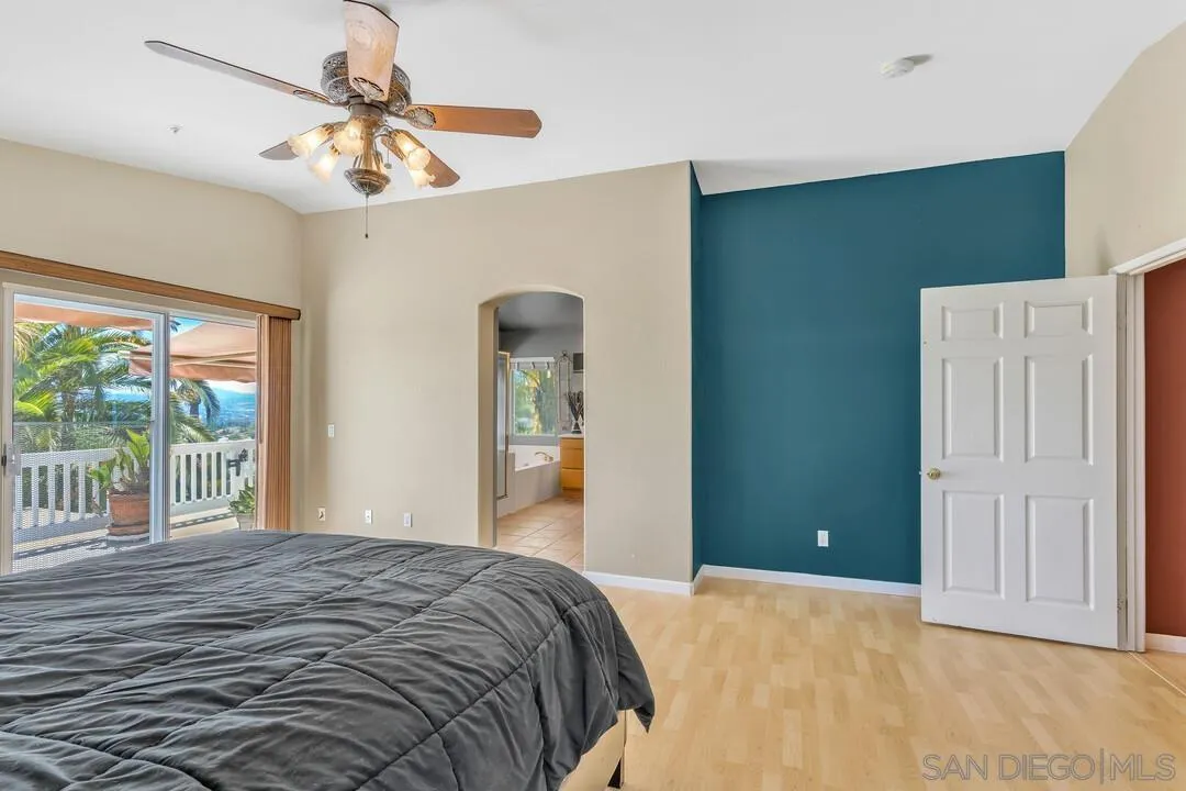 10496 Chaparral Drive Santee, CA 92071 - Photo 27 of 73 a bedroom with a large bed and a chandelier