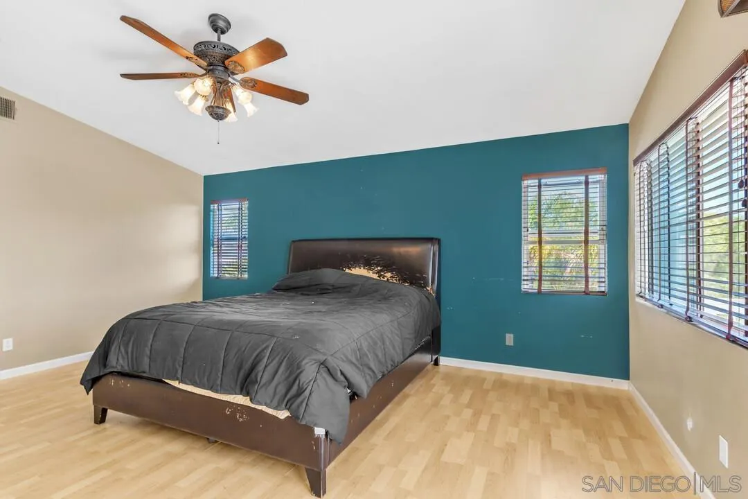 10496 Chaparral Drive Santee, CA 92071 - Photo 28 of 73 a bedroom with a large bed and a chandelier