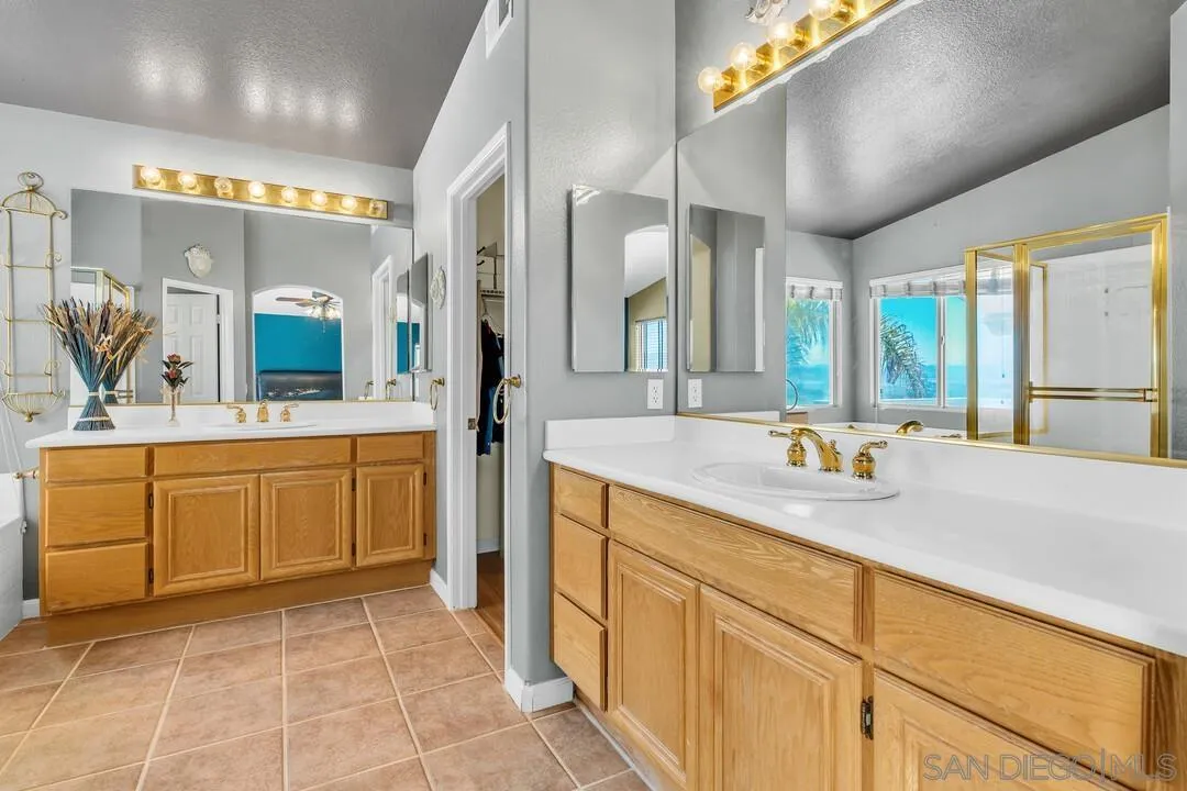 10496 Chaparral Drive Santee, CA 92071 - Photo 34 of 73 a bathroom with a sink a vanity a mirror and a bathtub