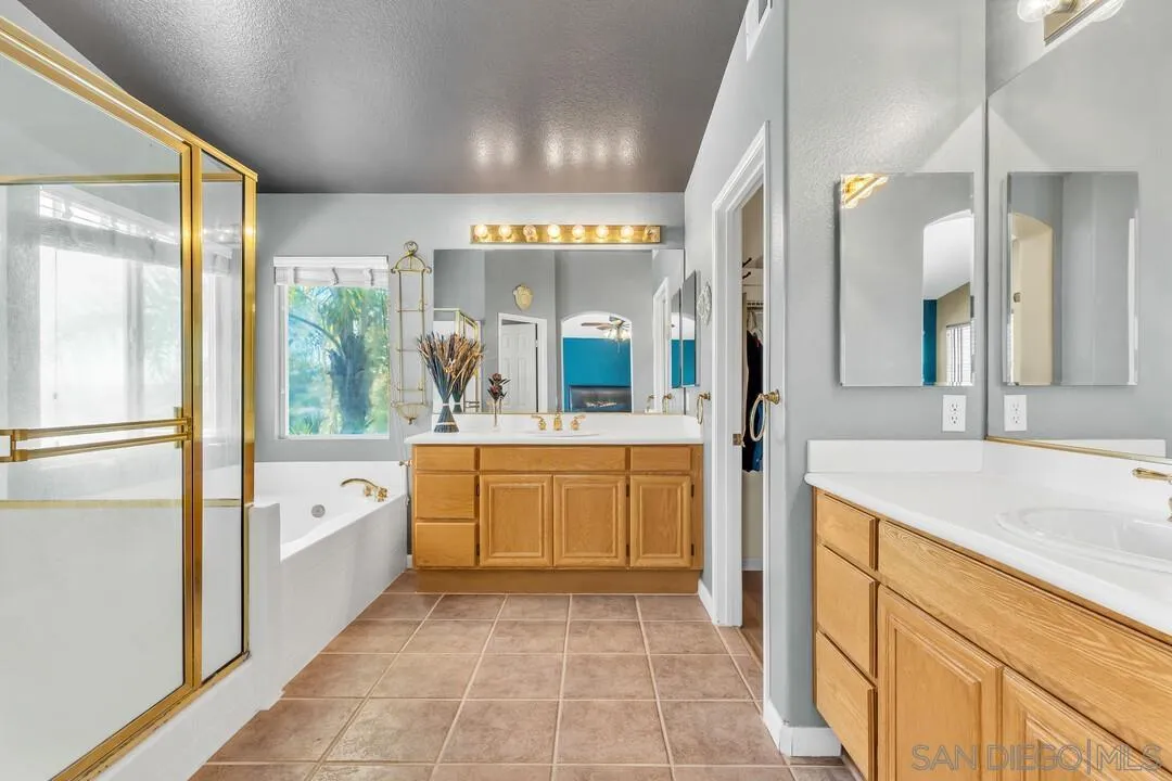 10496 Chaparral Drive Santee, CA 92071 - Photo 35 of 73 a large bathroom with a granite countertop double vanity sink a mirror and a bathtub