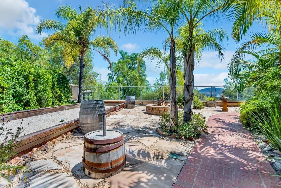 10496 Chaparral Drive Santee, CA 92071 - Photo 57 of 73 a view of a patio with table and chairs potted plants and palm trees