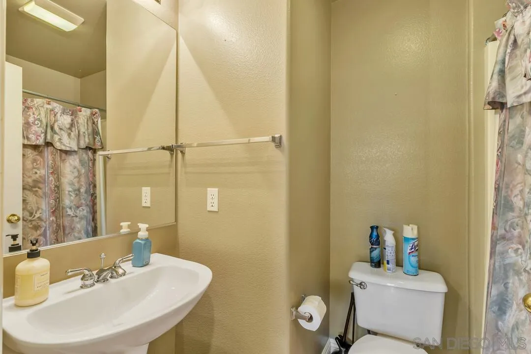 10496 Chaparral Drive Santee, CA 92071 - Photo 9 of 73 a bathroom with a sink mirror and toilet