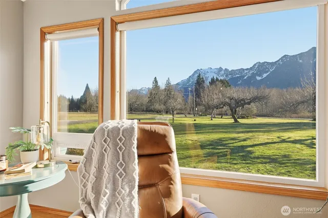 a living room with a bed and a floor to ceiling window