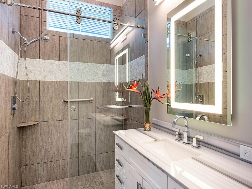 555 Mooring Line Drive Naples, FL 34103 - Photo 25 of 27 a bathroom with a sink and a mirror
