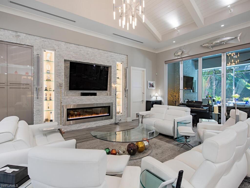 555 Mooring Line Drive Naples, FL 34103 - Photo 7 of 27 a living room with furniture a flat screen tv and a fireplace
