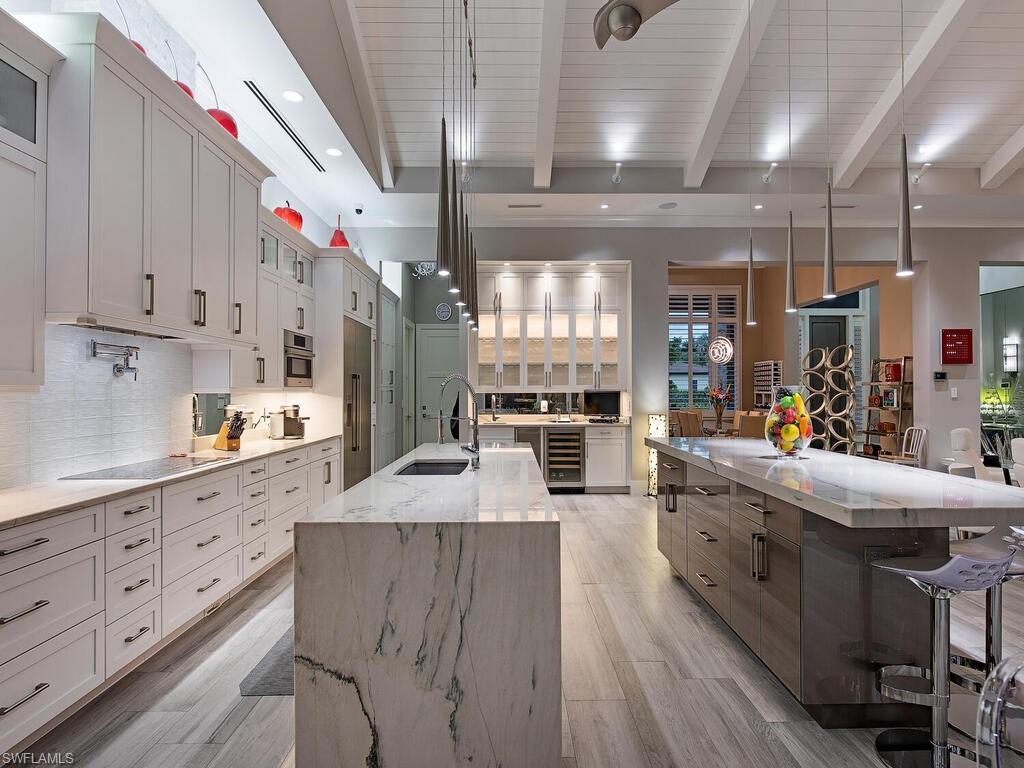 555 Mooring Line Drive Naples, FL 34103 - Photo 9 of 27 a large white kitchen with lots of counter space and wooden floor