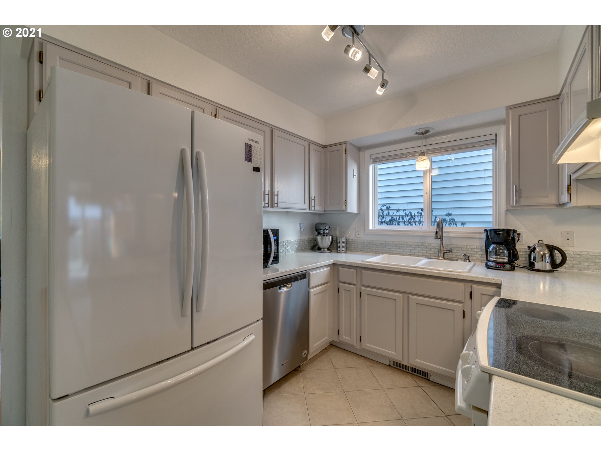 16934 Southwest Steele Way Beaverton, OR 97006 - Photo 8 of 27 a kitchen with white cabinets and white appliances