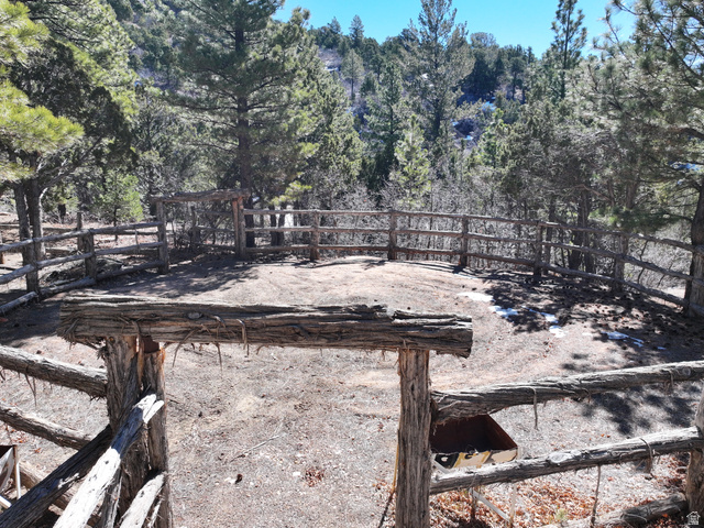 700 West Gravel Road North Kanab, UT 84741 - Photo 17 of 63 Fenced outdoor enclosure with a wooden gate, surrounded by mature trees